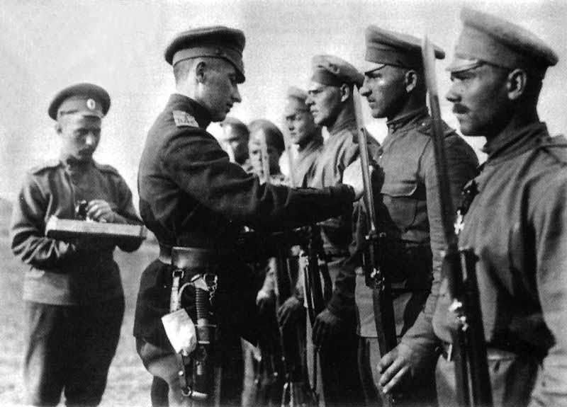 Капитан Ф. А. Бриедис награждает стрелков 1-го Усть-Двинского латышского батальона. Лето 1916 года